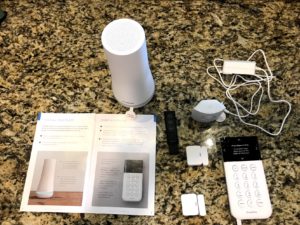 SimpliSafe equipment shown on a countertop next to an open user guide